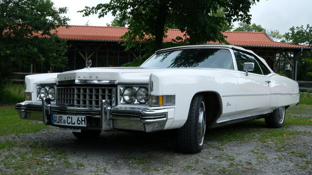 L&uuml;tetsburg, Germany - July 9 2026 An impressive white Cadillac Eldorado convertible from 1973 is parked on grass. It is a wedding car rental