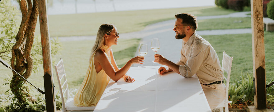 Couple enjoying drinks in a serene outdoor setting during golden hour