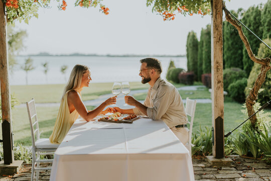 Couple enjoying a romantic dinner by the lakeside at sunset