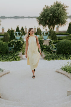 Strolling gracefully through the lush garden by the serene lake at dusk