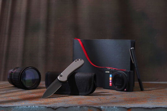 Automatic folding pocket knife under cinematic warm and cool contrast lighting.