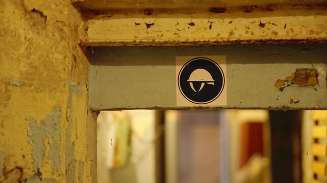 Safety Helmet Required Warning Sign On Old Rusty Door Frame In Abandoned Industrial Building. Warning Workplace Protection 