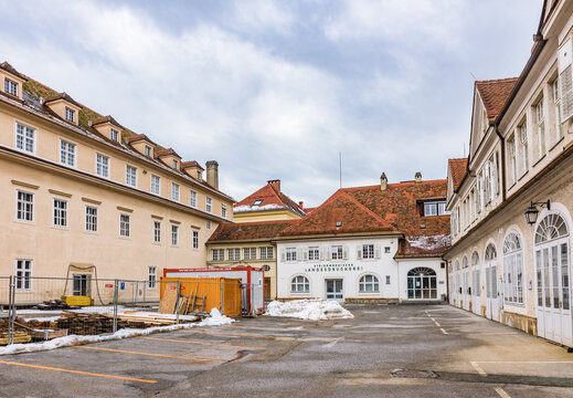 The historic courtyard of the Grazer Burg (Graz Castle) complex under renovation and the Steiermarkische Landesdruckerei building in the old town of Graz.