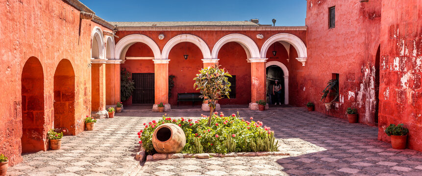 Vibrant interior passage of the Santa Catalina Monastery in Arequipa leading into a serene courtyard framed by historic colonial architecture