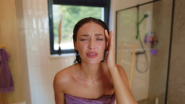 Beautiful woman checking her face skin and looking concerned about possible skin problem, blemish or wrinkle, 4K