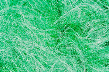 Obraz premium Close-up texture of a green nylon fishing net with tangled fibers and intricate woven patterns. 