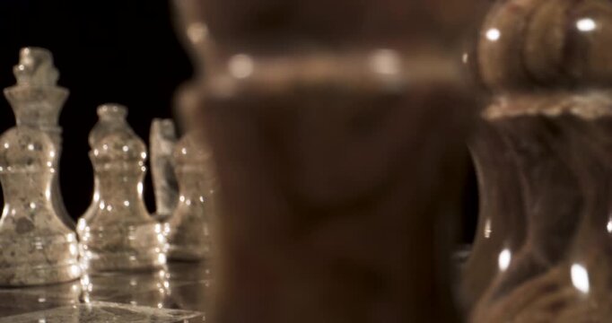 Chess pieces on the board in a close-up view with dark background