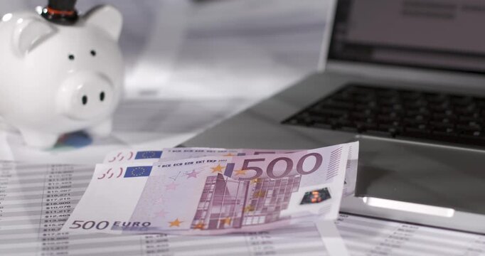 Euro banknotes falling beside laptop in super slow motion