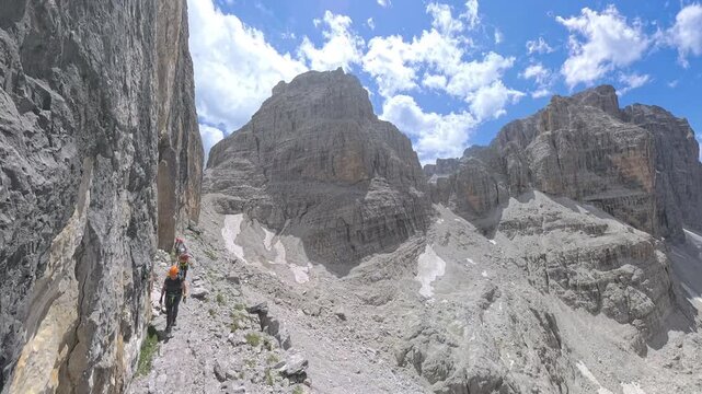 Group of hikers traversing Via Ferrata Bocchette Centrali with panoramic views toward Bocca di Brenta