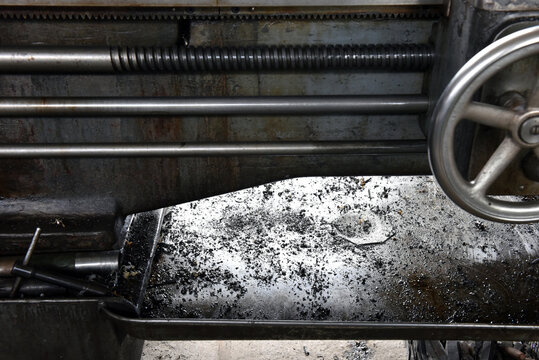 Industrial metal lathe bed with metal shavings and mechanical parts