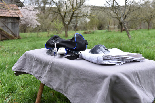 Grooming and hair cutting kit on a draped table in an outdoor setting