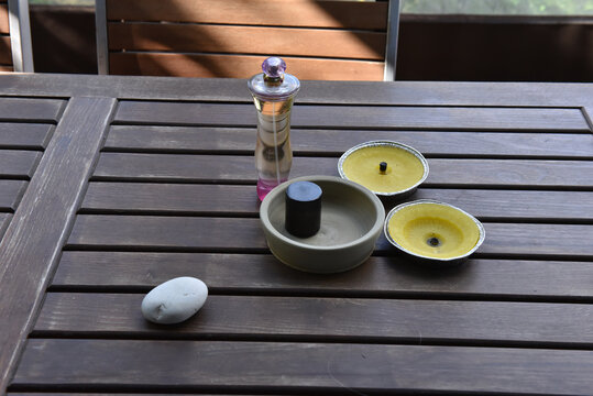 Flat lay of perfume bottle and yellow candles on a slatted wooden table