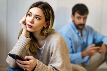 Gadget addiction and relationship problems. Couple with smartphones ignoring each other © NDABCREATIVITY