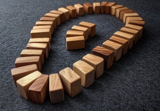 rows of small wooden blocks arranged into a question mark on dark textured fabric, evoking curiosity and mystery
