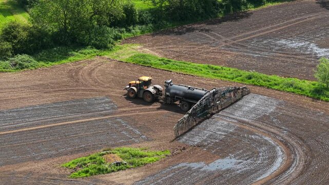 Organic manure fertilization tractor working across arable field for soil regeneration. Nutrient management process increasing crop productivity, sustainable farming output, agricultural efficiency