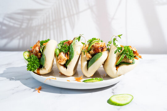 Asian street food chicken teriyaki bao buns served on a plate.