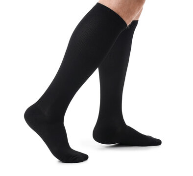 Person wearing black compression socks for medical support and improved circulation, isolated on a white background, These socks are designed for health and wellness