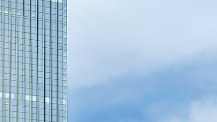 Obraz premium Modern Glass Skyscraper with Copy Space and Blue Sky, for Commercial Real Estate, Office Leasing, Property Investment, Corporate Development, and Urban Architecture