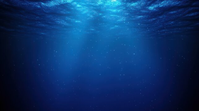 Deep blue underwater scene with sunbeams piercing the rippled surface and tiny suspended particles, evoking calm serenity and quiet mystery