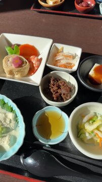 Varied dishes of a traditional yuba tofu Japanese meal served on a wooden tray in a restaurant