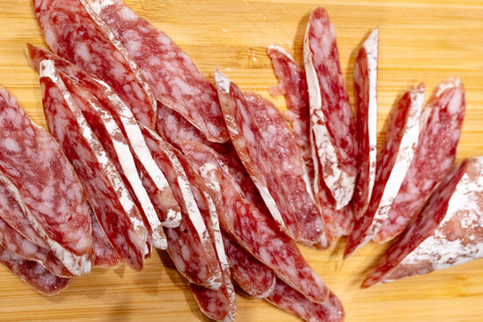 Sliced fuet sausage on wooden board closeup