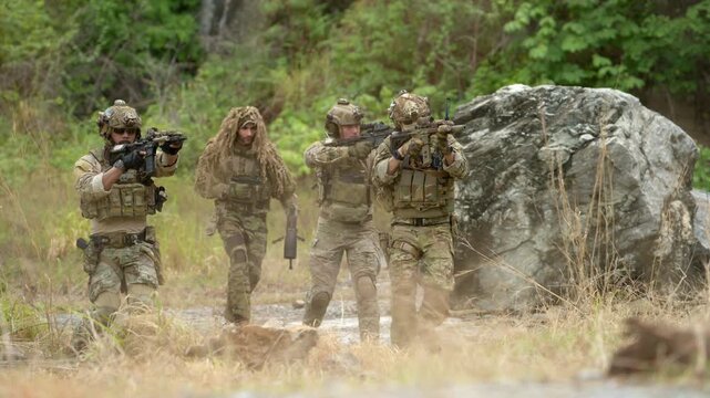 Special operations soldiers react to a controlled explosion during a tactical military training exercise in rugged outdoor terrain