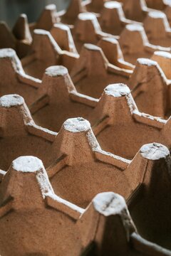 Cardboard egg carton tray with empty cells. Sustainable packaging material view. Recyclable paper product for food storage. Environmental conservation and ecological recycling concept.