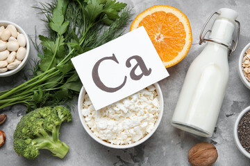 Obraz premium Paper with symbol of calcium and healthy products on grunge background