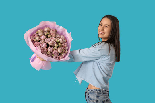 Young woman with bouquet of beautiful roses on blue background
