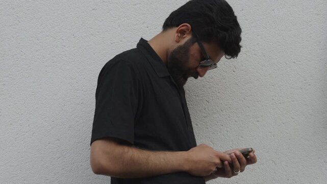 Side profile of man in black shirt using mobile phone outdoor