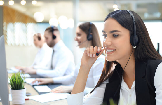 Portrait of call center worker accompanied by his team. Smiling customer support operator at work.