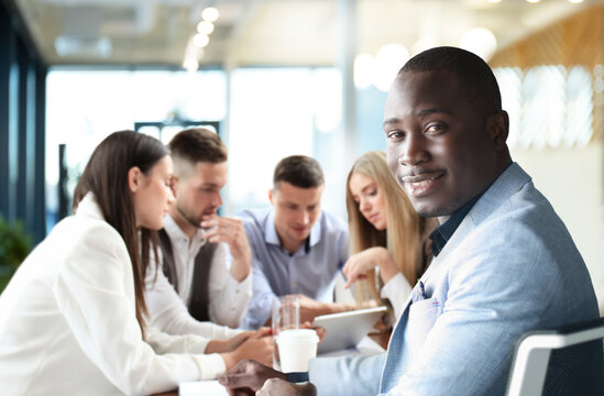 Businessman with colleagues in the background in office.