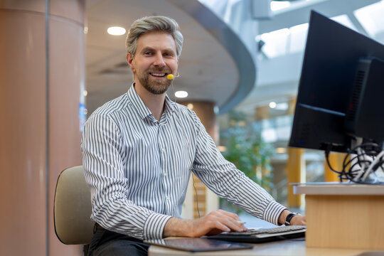 Smiling friendly handsome young male call centre operator.