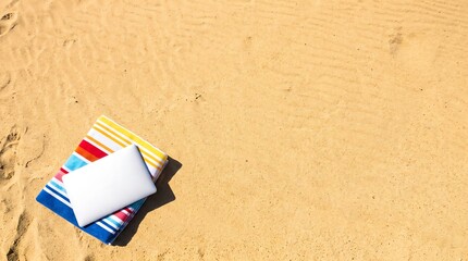 Closed Laptop on Beach Towel and Sand Holiday Copy Space