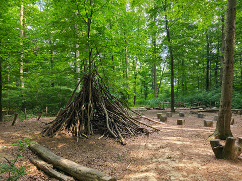 germany, creative wooden branch tipi beside forest kindergarten gathering place encouraging outdoor learning and imaginative summer adventures near wendlingen