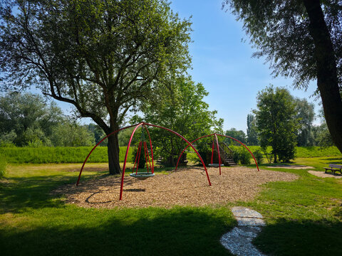 germany, inviting playground surrounded by lush green trees under brilliant blue summer sky offering joyful family recreation in plochingen park