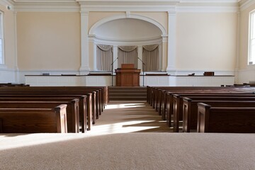 Obraz premium The Courtroom Interior with Empty Pews and Sunlit Central Podium