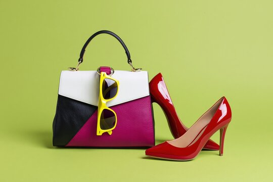 The Handbag With Yellow Sunglasses And Red High Heels In Studio