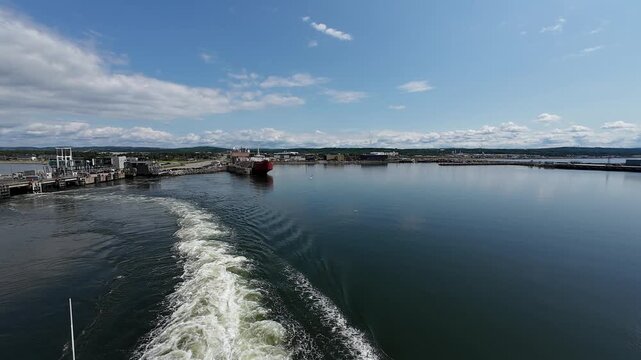 Rear deck perspective of a passenger ferry leaving Matane Port on Quebec's St. Lawrence coastline.