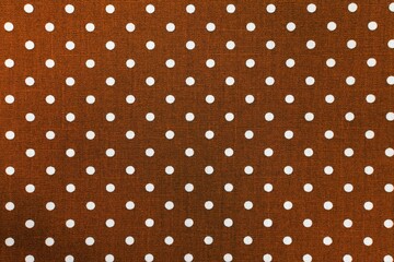 Brown fabric with white polka dots texture. Polka dot pattern close-up. Textile background © Iqra