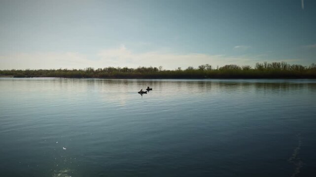 Tranquil Minimalist Waterscape: Solitary Row Boats with Fishermanes Gliding on Mirror-Like Lake at Golden Hour