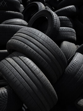 Pile of worn used car tires . Concept of tire waste, recycling, automotive industry, environmental pollution, and end-of-life vehicle components.