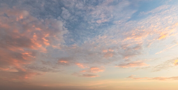 Beautiful sunset sky background with soft pastel pink orange clouds and clear blue azure light for panoramic travel mockup design