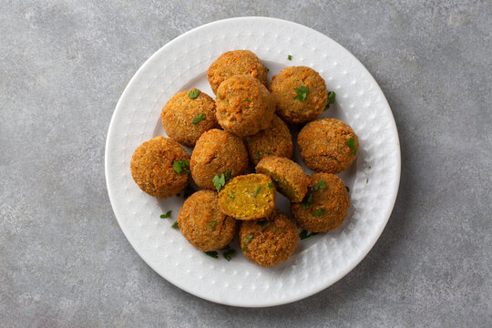 Overhead view of crispy golden falafel balls served on a textured white plate