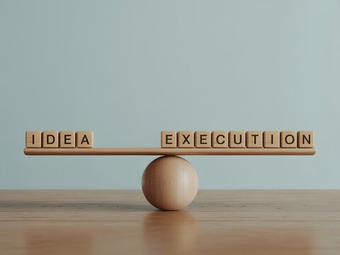 A wooden seesaw with blocks spelling out idea and execution in balance on a table
