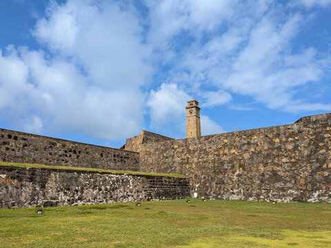 Historic Galle Fort Outer Stone Walls with Galle Clock Tower Under Blue Sky in Galle Sri Lanka