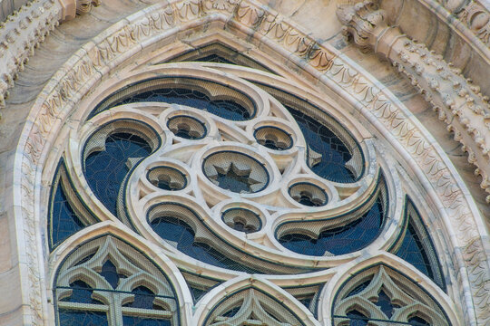 Gothic Rose Window with Ornate Stone Tracery and Geometric Patterns on the Facade of a Cathedral Duomo di Milano. Architecture Detail of Milan Italy