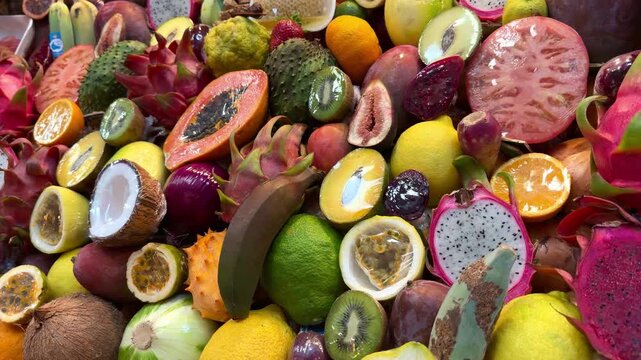 Colorful assortment of tropical fruits including dragon fruit, papaya, and passion fruit arranged in a vibrant display at a market setting with bright colors and textures