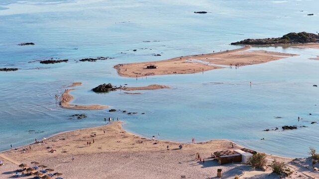 Aerial drone view of sandbars and rocky outcrops in a calm shallow turquoise lagoon, Elafonissi, Greece