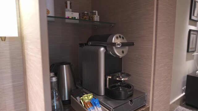 Premium espresso capsule coffee maker and electric kettle refreshment tray amenity in a luxury hotel suite.